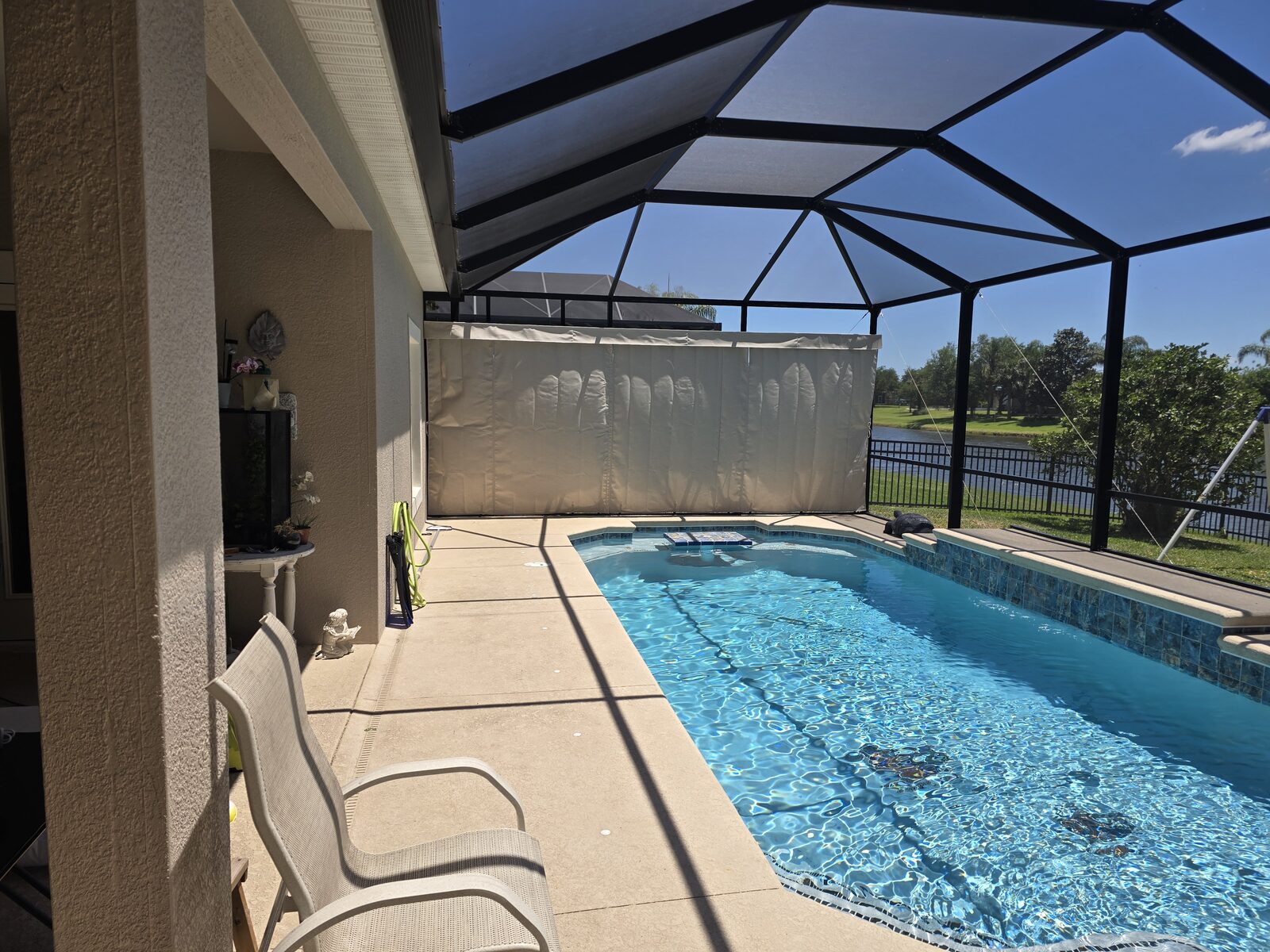 Outdoor privacy curtains beside a screened pool