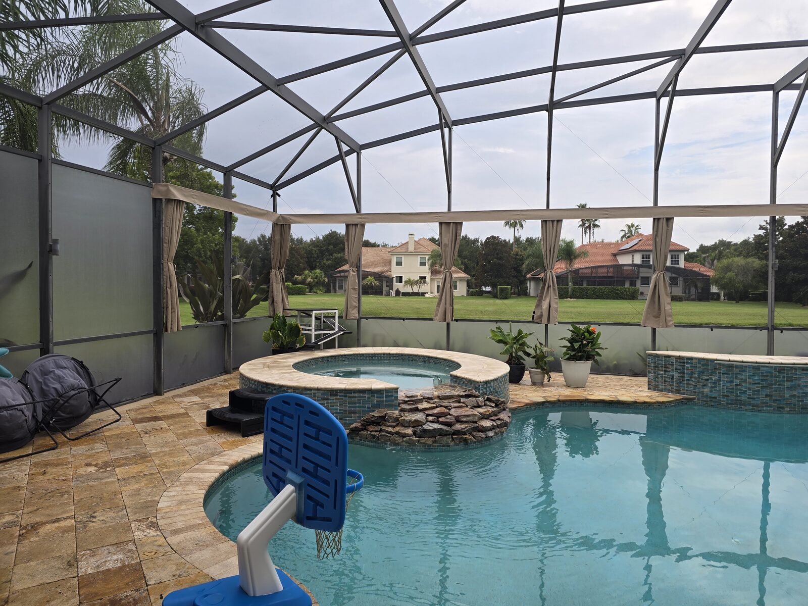 Screened pool enclosure transformed with privacy curtains