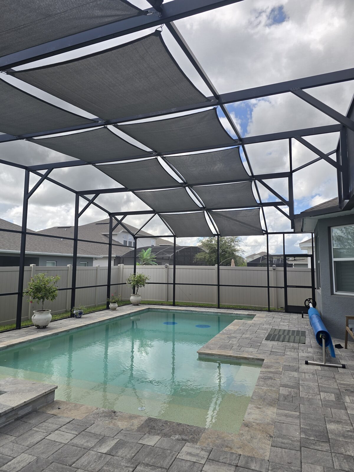 Custom shade sails over a screened pool enclosure
