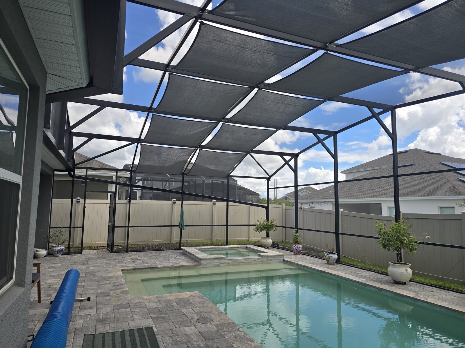 Shade sails installed across a screen enclosure